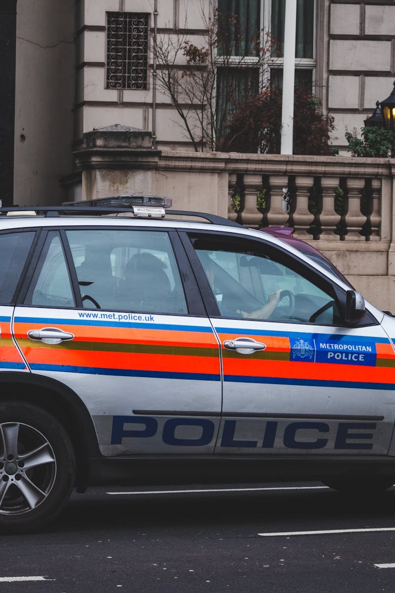 Police vehicle parked on an urban street outside a London building