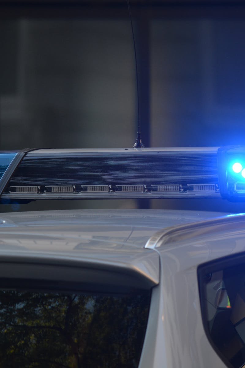Close-up of a police car's flashing blue lights in an urban environment.